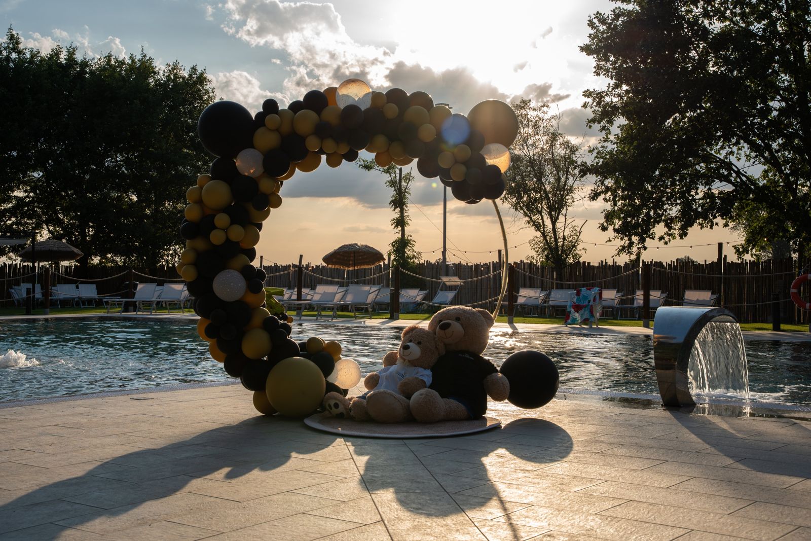 Piscina e arco di palloncini al tramonto
